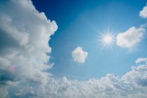 blue sky a border of clouds and the sun shining