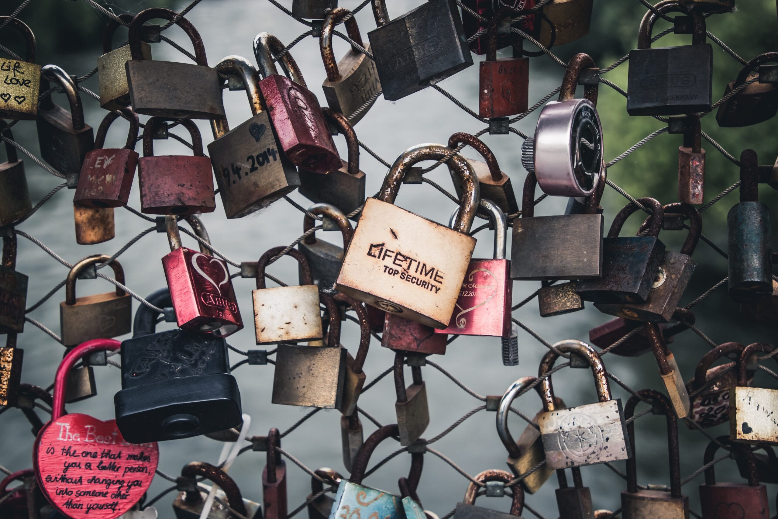 loads of padlocks on a wire fence with the centre one engraved with the word lifetime
