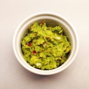 a white ramekin with guacamole