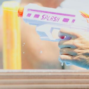 a hand shooting a water pistol
