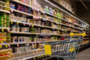 supermarket fridge shelves with a trolley in front